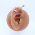 Detail view of a butterfly industrial barbell piercing with colorful rhinestones on a silicone ear model - Style #5 Colorful Gem Butterfly