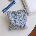 Dettaglio del sacchetto in cotone a fiori blu con chiusura a coulisse su legno bianco - Blu Klein
