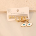 Close-up of gold stainless steel earring set with blue evil eye charms on stone surface - 3 Pairs Mixed Blue Eye Earring Set (6#)