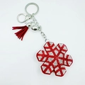 Detailed view of red snowflake keychain with white rhinestones and red tassel decoration - Red Green Snowflake