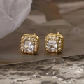 Macro shot of gold-plated square stud earrings featuring princess-cut cubic zirconia - Clear
