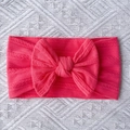 Detail of bright pink cable knit baby headband featuring a large soft decorative bow - Rose Red