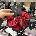 Detail of red and black satin scrunchie with smooth silk texture and flower bud design - Large / Burgundy