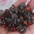 Miniature black resin ducks with red beaks displayed in hand to show small scale - Black