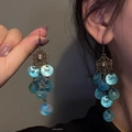 Close-up detail of New Chinese style tassel earrings with blue iridescent circular beads - Hook Style / Lake Blue