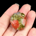 Pierre d'unakite polie sculptée en patte de chat avec motifs verts et roses sur fond noir - Unakite