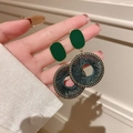 Detail of dark green woven round earrings with gold trim held in hand for scale - 10# Silver Needle - Deep Green Woven Round