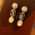 Détail de boucles d'oreilles dorées avec pierres roses, bleu foncé et ambre cristal - Boucles d'oreilles à clips Or Rose Gris