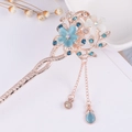 Macro shot of gold floral hair pin with blue cat-eye stone flowers and crystal tassels - Gold Blue White Cat's Eye Flower Tassel (FZ002)