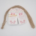Close-up of baby shower thank you tags with pink footprints and baby bottle motifs - 5-Baby Shower Pink