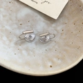 Close-up of silver geometric ear clip converters with comfortable clear silicone pads - Mosquito Coil Style / Silver
