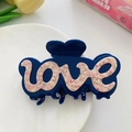Detail of dark blue acetate hair claw clip with pink marble LOVE lettering on white plate - 10x5cm / Blue and Sakura Pink
