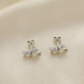 Elegantes pendientes de nudo plateados sobre fondo de seda champán para mujer - Color Acero