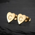 Macro shot of gold heart-shaped stainless steel stud earring with engraved letter C - Letter C / Gold
