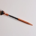 Macro shot of rose gold ballpoint pen with black natural raw stone and crushed crystals - Obsidian