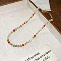 Gros plan d'un collier de perles colorées dans une boîte à bijoux beige avec carte - Bleu Rouge (45# Collier)