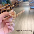 Elegant gold metal hair claw with white pearls in a 7.0cm twisted knot design - Cross Pearl