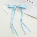 Detail einer hellblauen Satin-Schleife Haarspange mit langen Bändern auf weißem Grund - Hellgrün