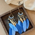 Macro detail of Bohemian tassel earrings with blue feathers and golden metal leaves - 7# Blue Enameled Seed Bead Feather Hook