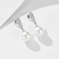 Primer plano de pendientes de perlas plateadas con circonitas sobre un fondo blanco puro - Plata 925 / Plateado