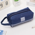 Portable navy blue double zipper pencil case with stripes and handle in a desk setting - With Letter Label / Navy Blue