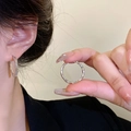 Elegant silver twisted hoop earrings for women featuring a minimalist luxury design - Spiral Twisted Hoop / Silver