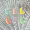 Close-up of colorful translucent resin letter L charms on a textured glass plate - Letter L