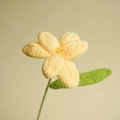 Handmade crochet yellow tulip flower with green leaf on a clean beige background - Yellow