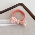 Pink elastic hair tie with textured bow detail on a rustic linen tray - Orange Pink