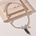 Detailed macro view of silver zircon butterfly pendant with black gemstone tassels - Silver Black Butterfly Fringe Necklace