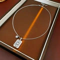 Detail van zilveren halsketting met hol vierkant hangertje en zirkoon in een juwelendoos - Zilver