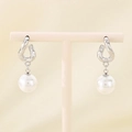 Detailed view of silver bow earrings with pearl drops displayed on a minimalist jewelry stand - Steel Twisted Ring (KE115800-GC)