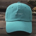 Detailed close-up of blue washed cotton Y2K baseball cap featuring NOT REALLY white embroidery - Lake Blue