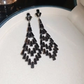 Dettaglio di lunghi orecchini a nappa neri con zirconi in una scatola per gioielli bianca - Stile Nappa in Zirconia Nera (Perno in Argento S925)