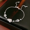 Primer plano de pulsera plateada con dije de corazón y perlas sobre caja de cuero - Plata - Corazón Hulu Perla Cordón
