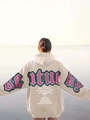 Outdoor view of oversized beige hoodie with vintage green and pink back letter print - S / Apricot