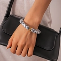 Dettaglio del bracciale geometrico in acrilico maculato con eleganti anelli dorati - Leopardo Bianco
