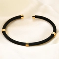 Macro view of black stainless steel mesh cable bracelet with polished gold-tone metal beads - Gold Black