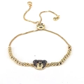 Dettaglio di un bracciale a orsetto dorato regolabile con pavé di zirconi scuri e chiusura - Stile 5-Caffè