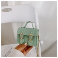 Detail of a mint green jelly PVC satchel bag with gold chain strap held by a hand - Light Green