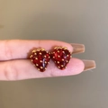 Dettaglio di un orecchino a fragola rossa sul dito per mostrare le dimensioni reali - 5# Silver Needle - Regolare - Rosso