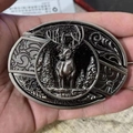 Close-up of a gun-black oval belt buckle featuring a 3D stag and forest relief design - Mountain Elk