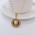 Golden lion head pendant necklace with black base and green eyes on white ceramic background - Gold / Lip Chain
