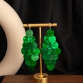 Macro detail of emerald green layered resin disc earrings on a gold display stand - H3478-1 Style