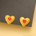 Nahaufnahme der roten Herzohrringe mit goldener Radialstruktur auf grauem Grund - Gold Rotes Herz / Gold