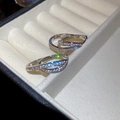 Close-up of silver U-shaped earrings with zircons and starburst light effect in a jewelry box - Silver (18K Gold Plated)