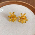 Dettaglio di orecchini a fiore dorati vintage con perle su un cuscinetto in tessuto beige - Oro