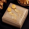 Elegant gold tassel earrings with round studs and snake chains on jewelry box - Gold