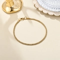 Detailed close-up of 18K gold stainless steel bracelet with intricate woven texture links - Corn Chain Style