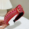 Detailed view of red knotted headband featuring intricate pink pearls and sequins - Red